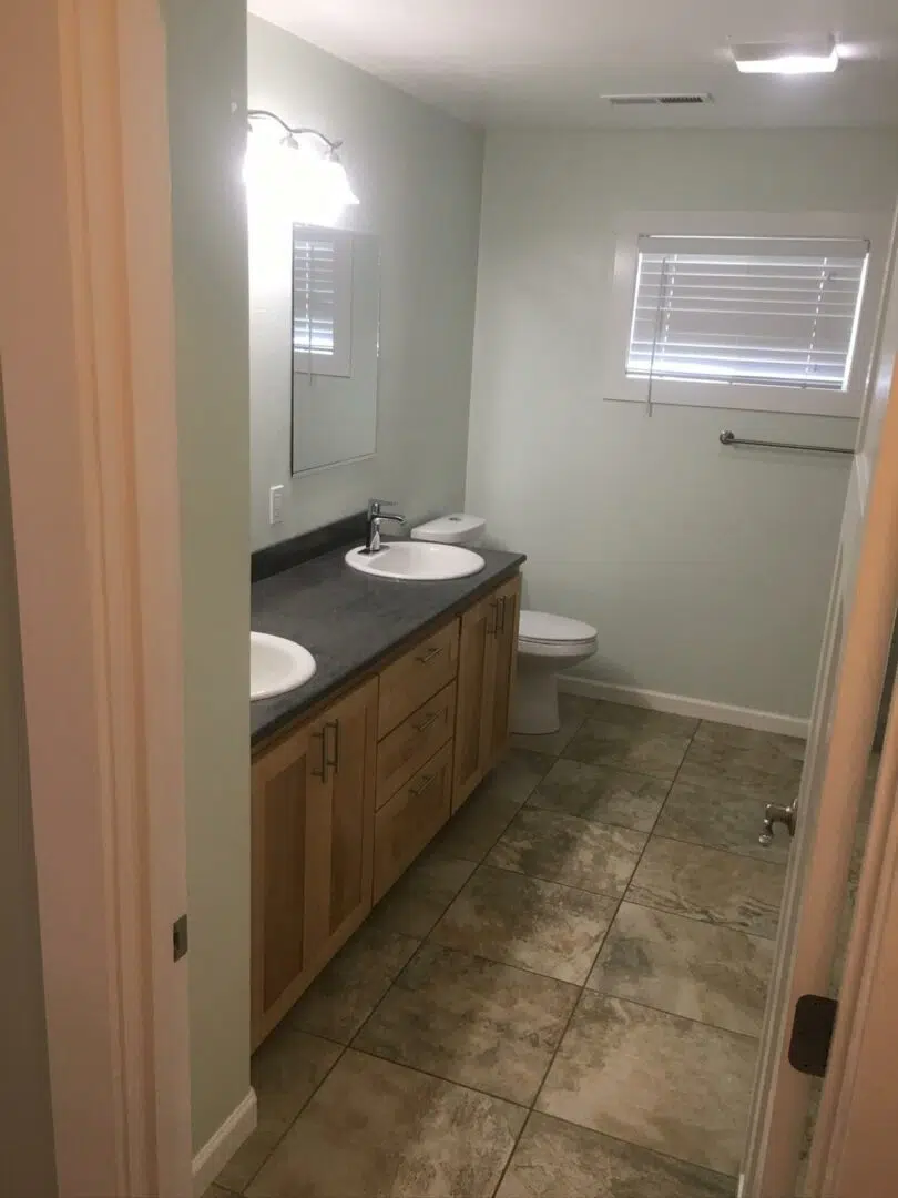 Bathroom remodel with updated double-sink vanity, tile flooring, and fresh wall finishes.